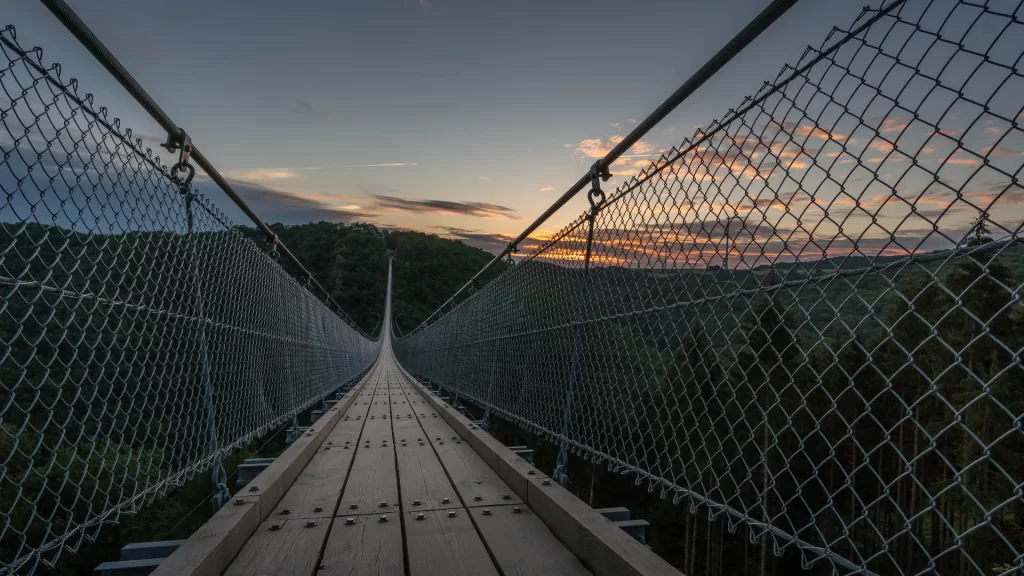 Suspension bridge extending through a landscape with sunset views, showcasing the angkula seo suspension bridge